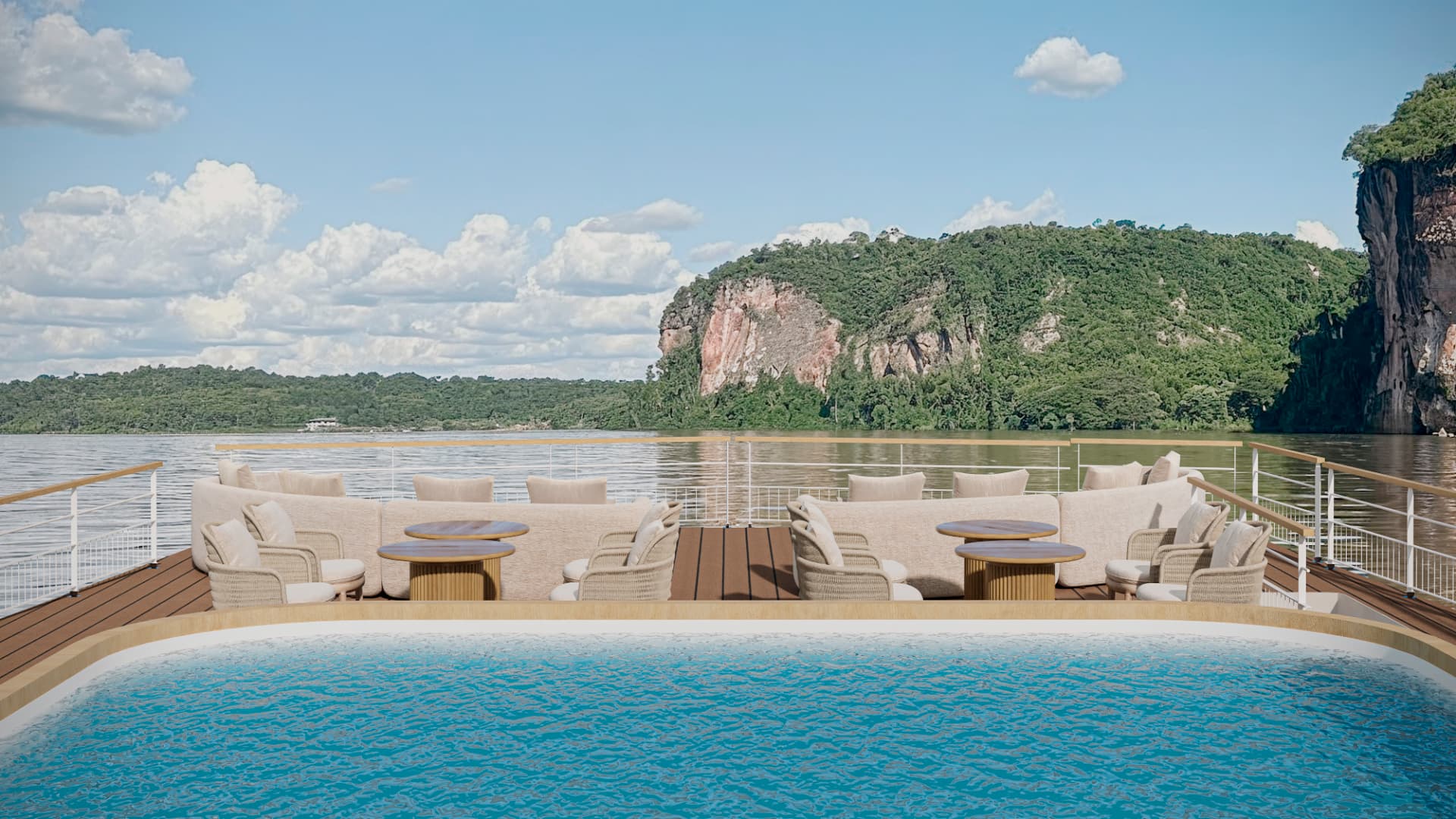 Pool deck with an infinity-edge pool and loungers facing the rainforest cliffs